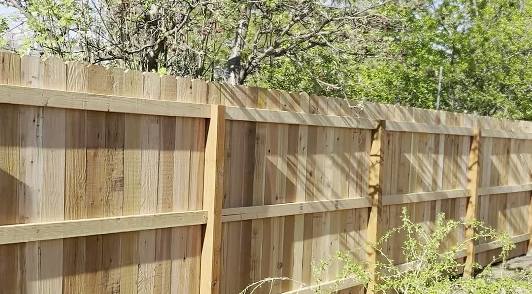 Cedar privacy fence line with posts and rails