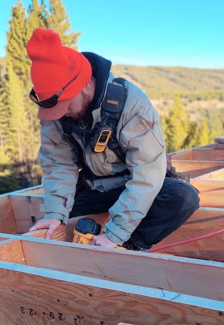Jeb Black, owner of Black Horizon Construction, framing in an orange beanie
