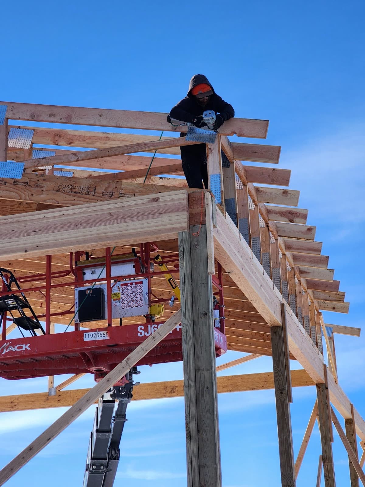 Jeb Black setting roof rafters from a lift
